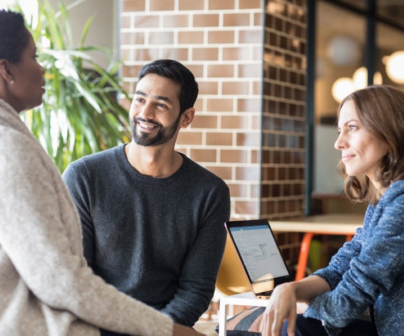 Man and two women chatting in office